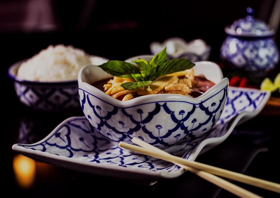 Grön curry med thaibasilika i en blå-vit porslinsskål med ris