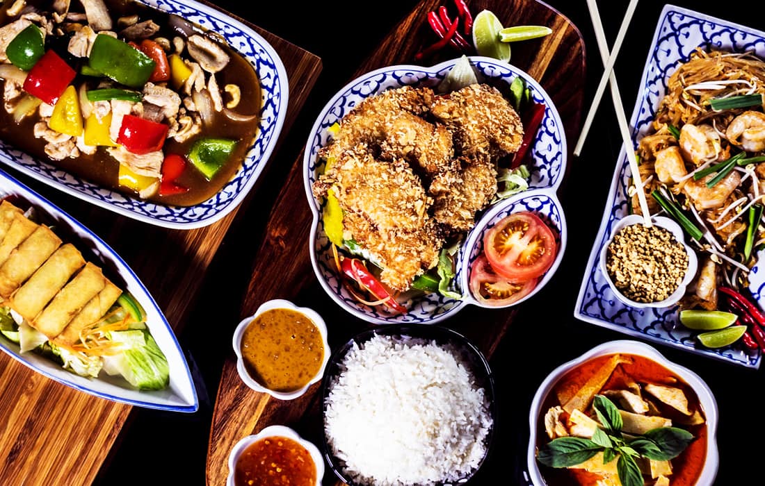 Bord dukat med thaimat – flera thailändska rätter, ris och såser